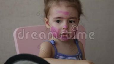 三岁的金发碧眼的婴儿在照镜子时，脸上画着彩色<strong>条</strong>纹